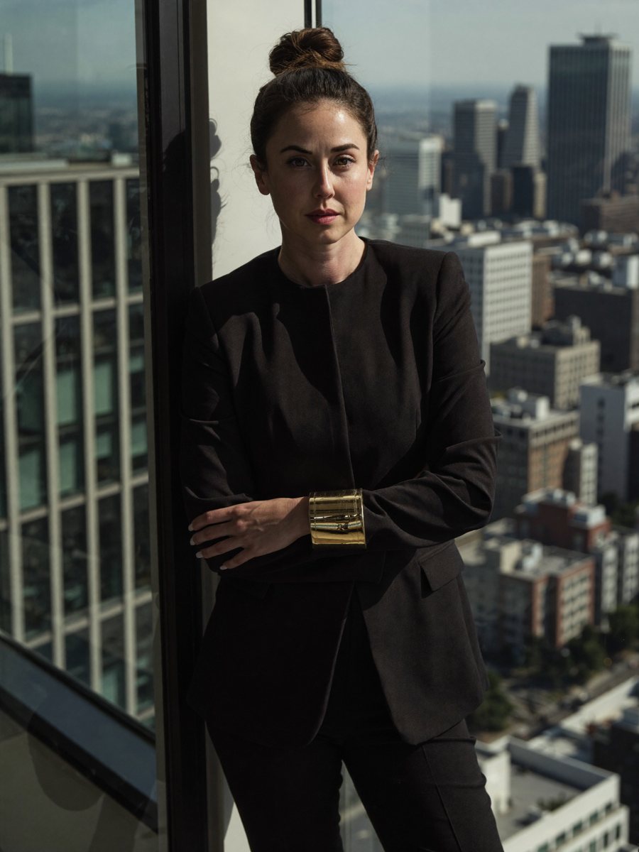 Shanté Micah in a black suit by a window above the city